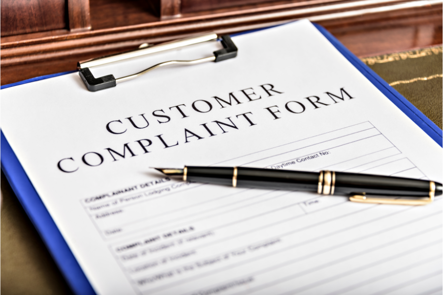 Customer complaint form on a clipboard with a pen, representing the process of submitting a complaint to a seller or service provider.