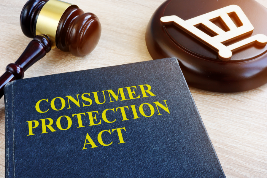 Gavel beside a wooden legal symbol and a book labeled “Consumer Protection Act,” illustrating consumer protection and access to consumer forums.